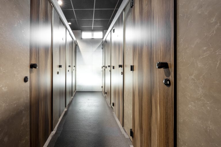 Smalle gang tussen houtlook cabines met daglicht aan het eind