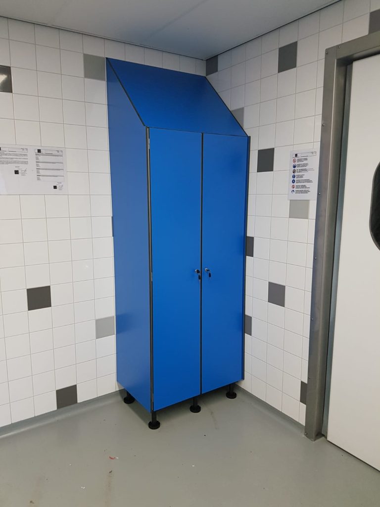 Hoge blauwe kast met schuine bovenkant in een betegelde ruimte