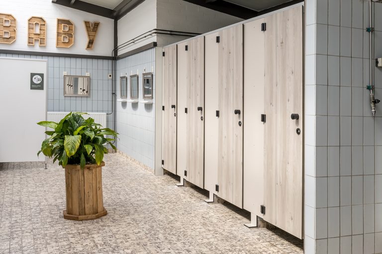 Rij lichte cabinedeuren met een plant in een houten bak ervoor