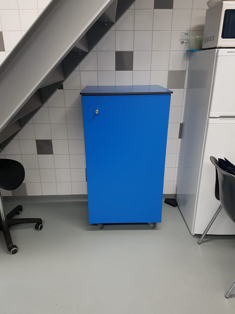Gesloten blauw kastje op wieltjes naast een bureaustoel