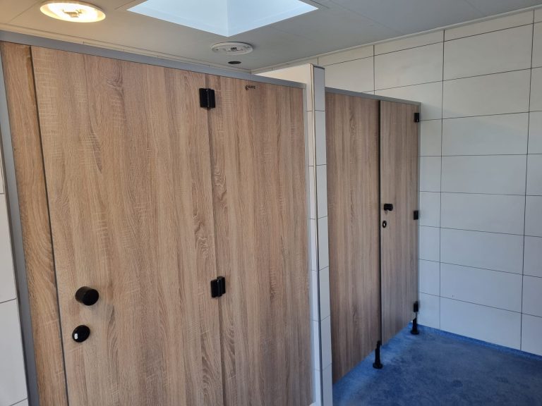 Houtlook cabinedeuren met zwarte knoppen onder een lichtkoepel